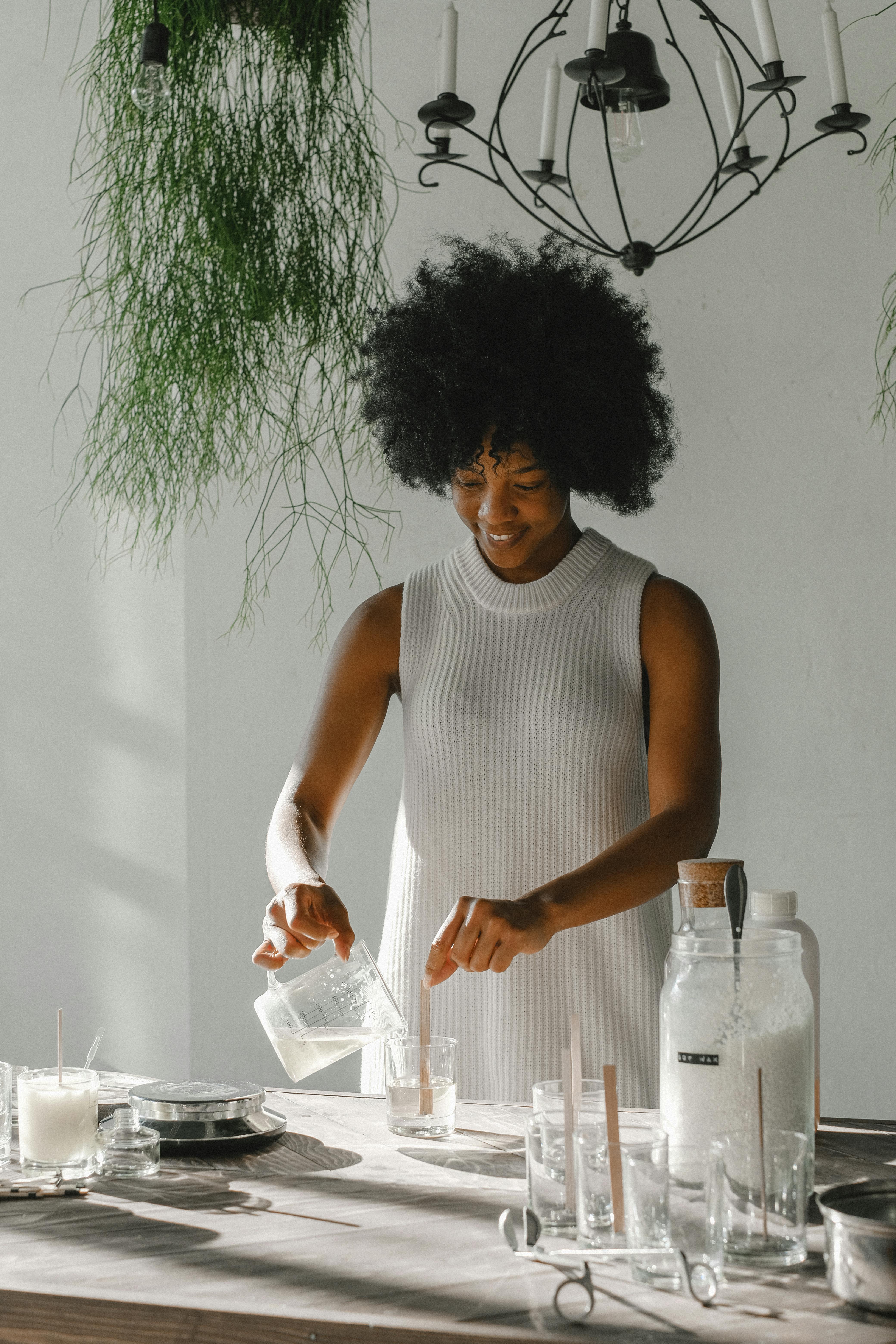  this image shows a lady in the process of making caldles  